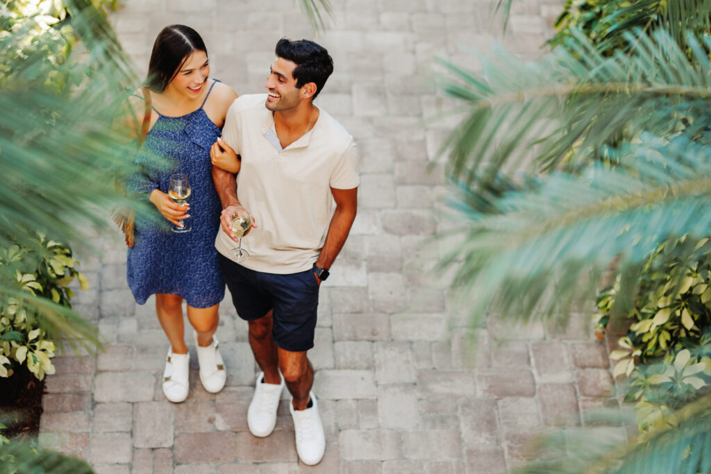 Couple walking outside enjoying a glass of wine